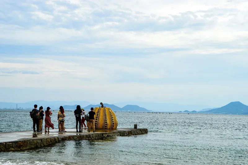 Escultura contemporánea amarilla frente al mar en una isla de arte